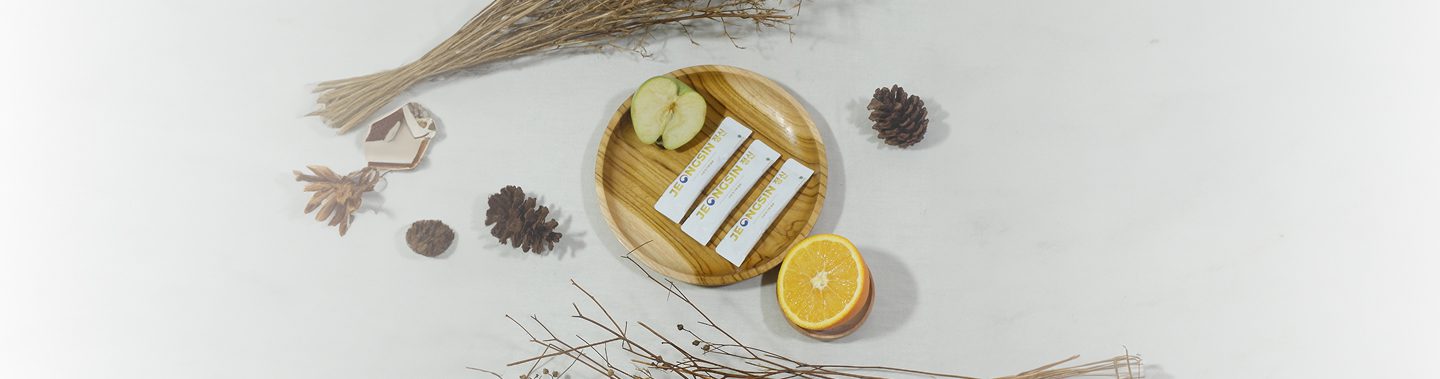Produk Jeongsin – suplemen vitalitas Korea berbahan alami disajikan di atas nampan kayu dengan buah segar